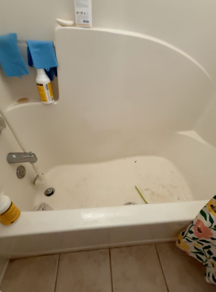A bathtub with visible grime and residue before cleaning.