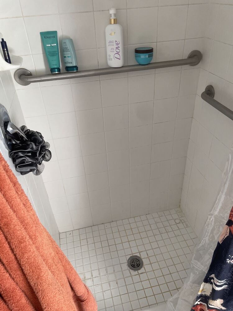 The same shower with clean white tile and grout after a Fresh Start deep clean.