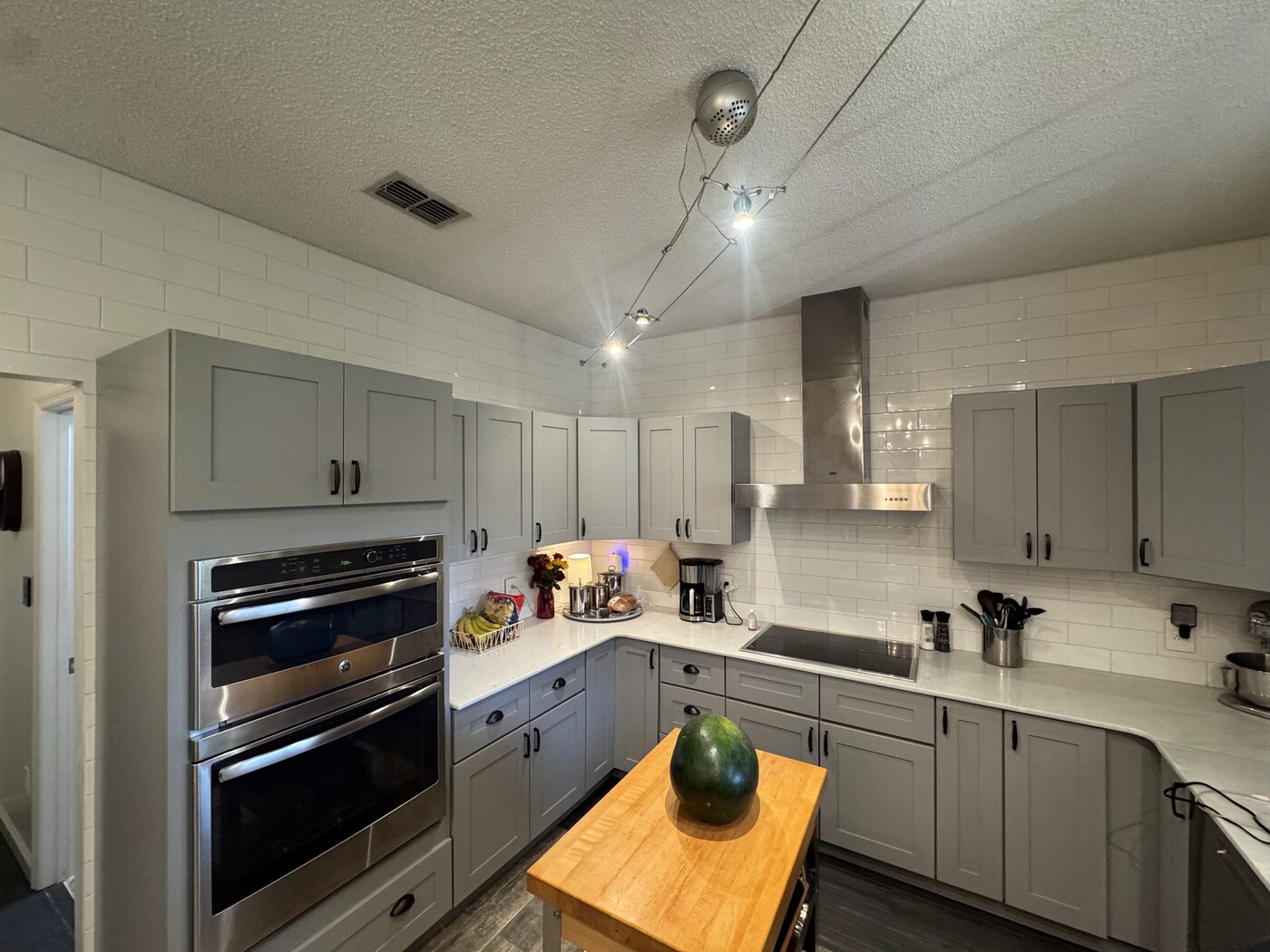 A spotless finished kitchen with gray cabinets and a gleaming countertop after a Fresh Start cleaning.