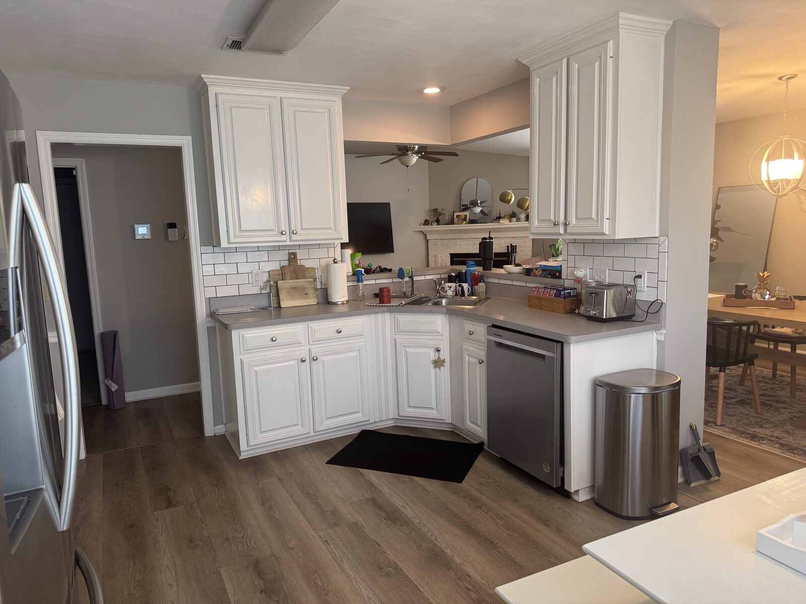 A bright, freshly deep-cleaned kitchen with white cabinets, wiped-down counters, and a spotless floor.