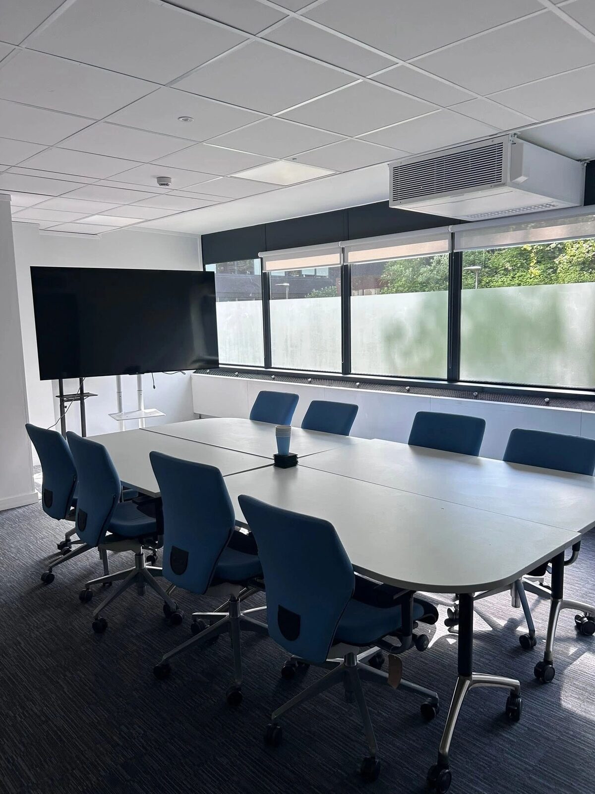 A small office conference room with a clean table, tidy chairs, and a presentable, ready-to-use space.